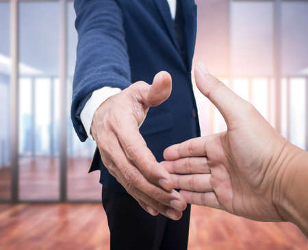 Two confident business man shaking hands during a meeting on office background,Close upの写真素材