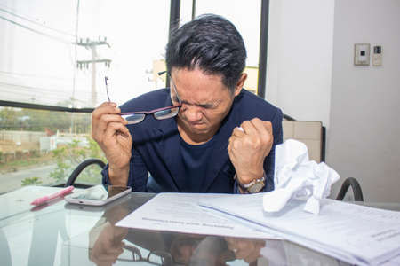 tired asian businessman in the officeの写真素材