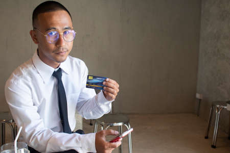Asian business man using cradit card for shopping online with smart phoneの写真素材
