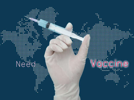 Gloved hand of doctor or nurse holding syringe with liquid vaccine before injectingの写真素材