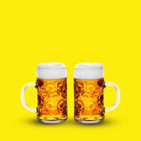 Two glasses of light beer on wooden yellow backgroundの写真素材