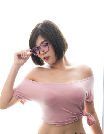 Young asian woman touching her eyeglasses over white backgroundの写真素材