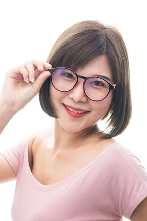Portrait of happy young Asian woman wearing blouse adjusting eyeglassesの写真素材