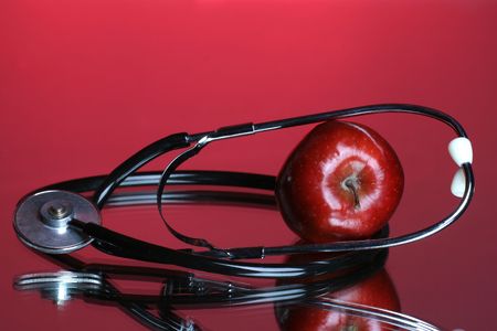 Stethoscope and apple on red backgroundの写真素材