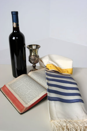 Holy Scriptures opened with Talid resting on it Kaddish cup and a bottle of red wine