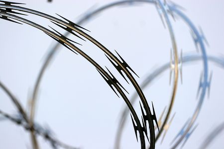 circle of barbed wire borders a boundaryの写真素材