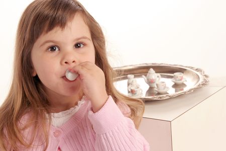 young girl takes a sip of her tea at the tea partyの写真素材