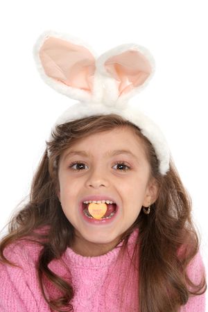 Cute girl with bunny ears holds a candy in between her teeth that reads sweet heartsの写真素材
