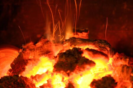 red hot sparks fly up from the fireの写真素材