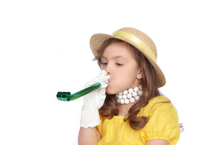 young girl blows on party favor to let you know its party timeの写真素材
