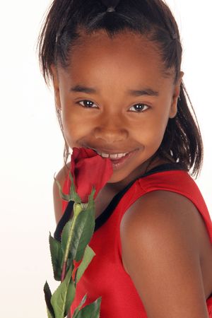 young African American girl smells her red roseの写真素材