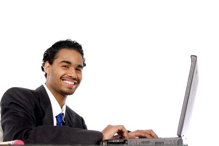 diligent young man smiling as he works on his computerの写真素材