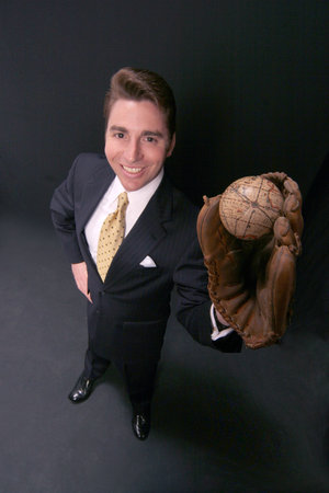 businessman holds the world in his glove on black backdropの写真素材