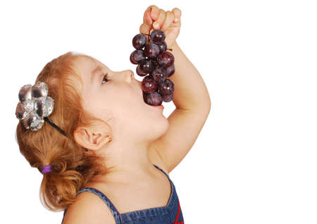 little girl eating grapeの写真素材