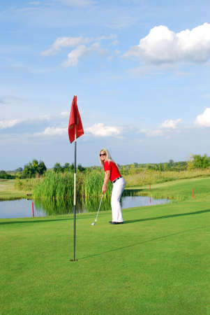 blonde girl playing golfの写真素材