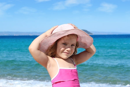 little girl with straw hat on beachの写真素材