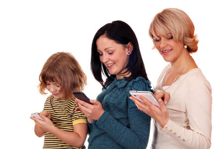 little girl teenage girl and woman playing with smart phone and tablet の写真素材