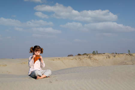 little girl play music on pan pipeの写真素材