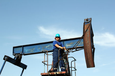 oil worker with sunglasses standing at pump jackの写真素材