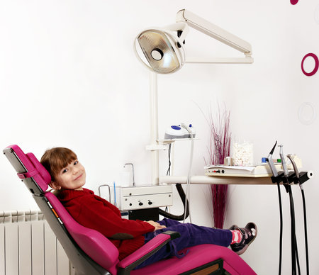 little girl sitting in dentist's chairの写真素材