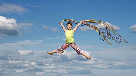 happy little girl with colorful ribbons on blue sky
