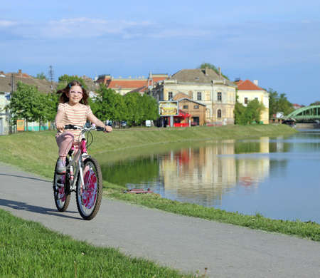little girl riding a bicycleの写真素材