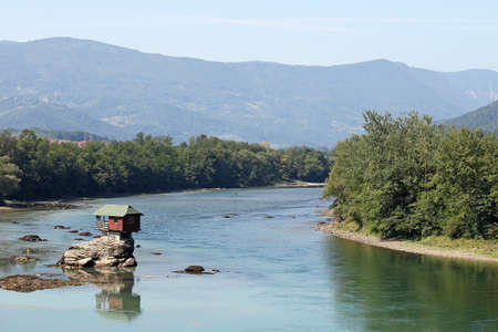 wooden house on rock Drina river Serbiaの写真素材