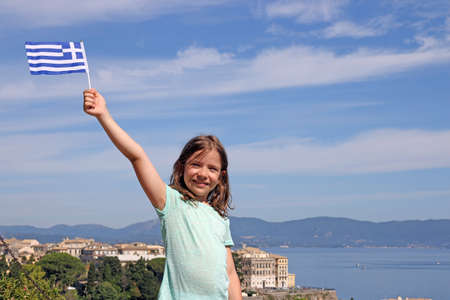 happy little girl with Greek flag on summer vacation Corfu town Greeceの写真素材