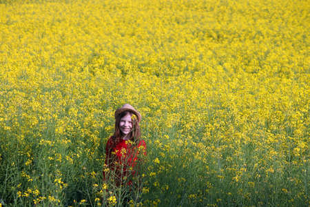 happy little girl on yellow field spring seasonの写真素材