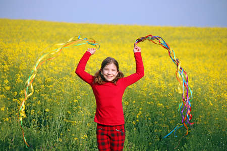 happy little girl playing on field spring seasonの写真素材