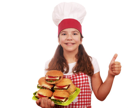 happy little girl cook with hamburgers and thumb upの写真素材