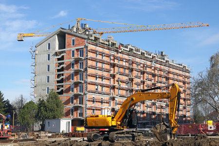 excavator and cranes on new building construction site 