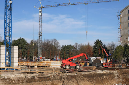 new building construction site with cranes and workers