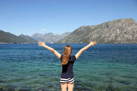happy little girl with hands up on summer vacation Kotor bay Montenegroの写真素材