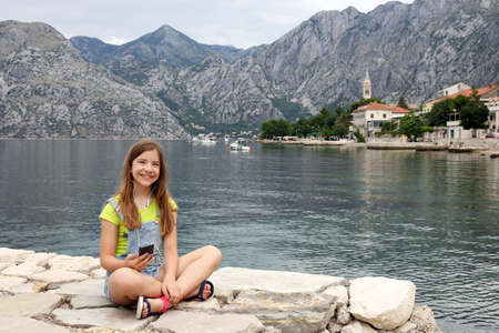 happy teenage girl with smart phone on summer vacation Kotor bay Montenegroの写真素材