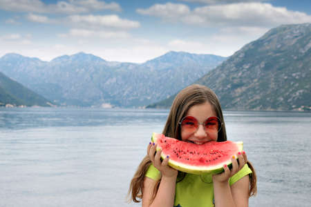 teenage girl with watermelon on summer vacationの写真素材