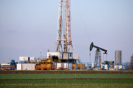 land oil drilling rig and pump jack in oilfield