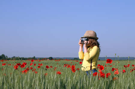 the little girl is taking pictures in the meadow spring seasonの写真素材
