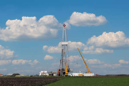 oil drilling rig and cranes on fieldの写真素材