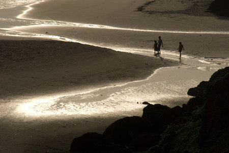 Children walking on a Varkala beach in Kerala, India.