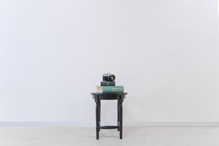 Modern chair with books and camera on white wall background, stock photoの写真素材