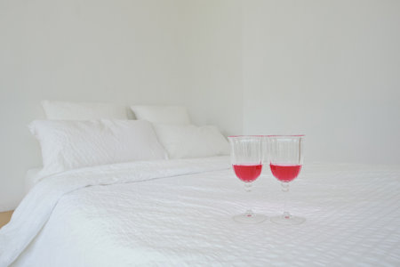 The white bedding and the white pillows make a mess when the wine glasses are spilledの写真素材