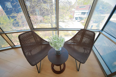 A chair made of rattan and a gypsophila on a table in a Southeast Asian accommodation