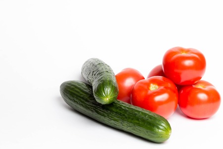 A few tomatoes and cucumbers on a white backgroundの写真素材