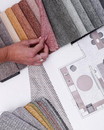 Female interior designer looking at colors. Creative way to do a project. Holding material in the...