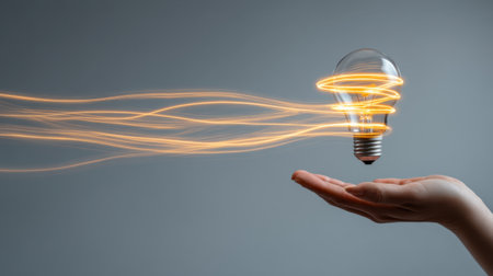 A glowing light bulb hovers above an open hand, emitting vibrant energy swirls. This image symbolizes creativity, innovation, and the spark of new ideas, perfect for themes of inspiration and modern design.の素材