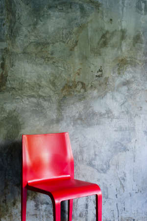Red plastic chairs at the corner of the room.の写真素材