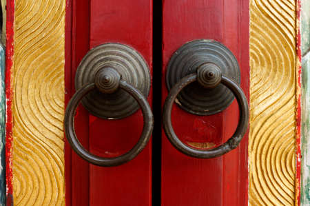 Old door ring handle on red wooden doorの写真素材