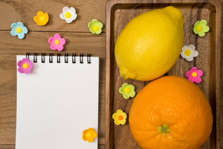 Citrus fruits. Oranges and limes. Over wood table background with opened notepadの写真素材