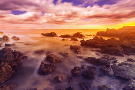 Scenic view of rocky beach, Long exposure of the wave during sunset on the beach.の写真素材